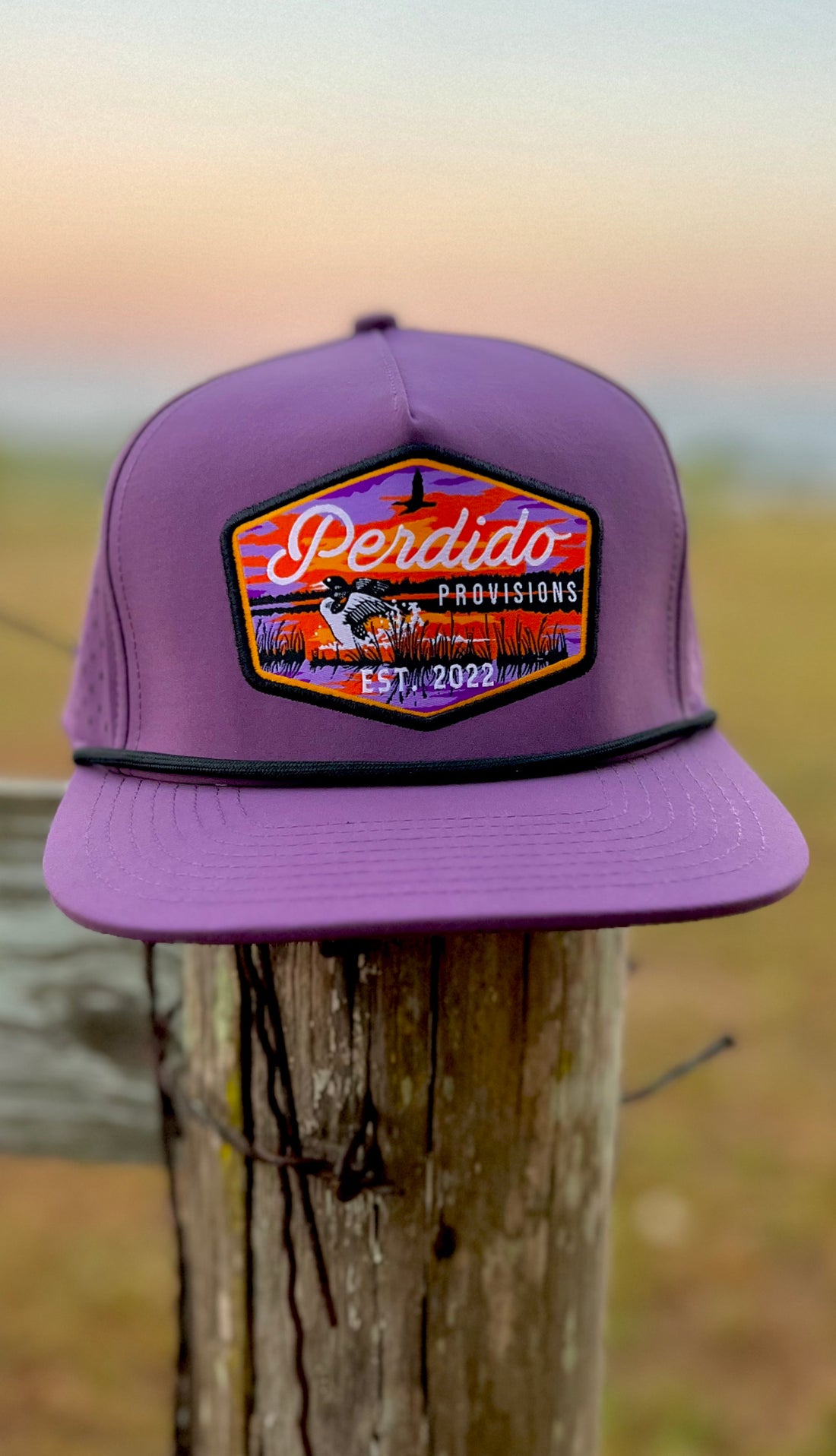 A purple 5-panel snapback cap with a logo on the front.