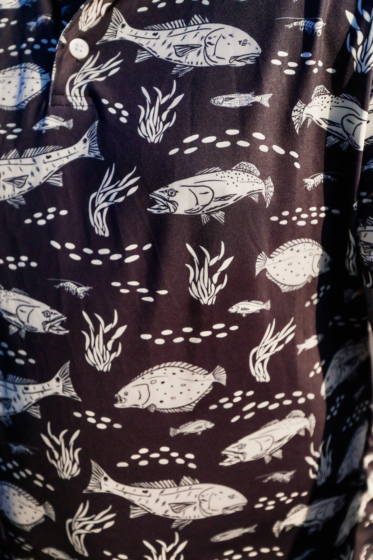 Close-up texture view of folded black Texas Slam print performance fabric.