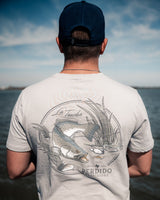 Man wearing La Trucha light grey t-shirt showing the large speckled trout back design outdoors.
