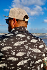 Close-up back view of man wearing black Texas Slam polo and hat.