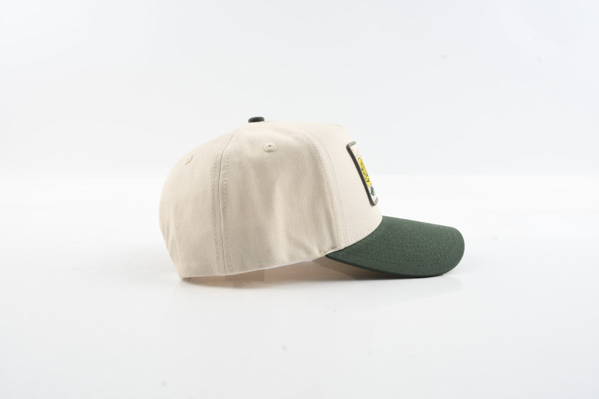 Side profile view of The Emily tan hat with curved green visor.
